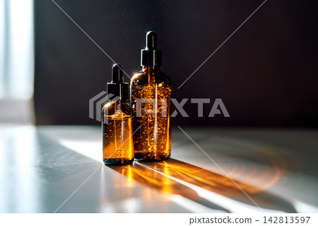 Amber glass skincare serum bottles with sunlight reflection Amber glass skincare serum bottles with sunlight reflection 142813597