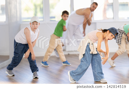 Girls and boys training hip hop in dance studio, dance classes for kids Girls and boys training hip hop in dance studio, dance classes for kids 142814519