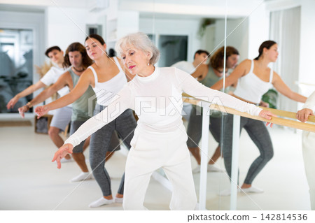 Elderly woman doing ballet at barre Elderly woman doing ballet at barre 142814536
