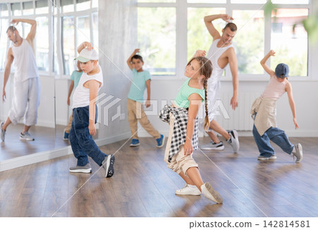 Dance group of children in casual clothes are training together to dance hip-hop and breakdancing in dance center Dance group of children in casual clothes are training together to dance hip-hop and breakdancing in dance center 142814581