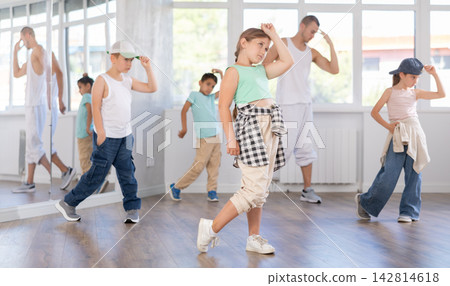 Girls and boys training hip hop in dance studio, dance classes for kids Girls and boys training hip hop in dance studio, dance classes for kids 142814618