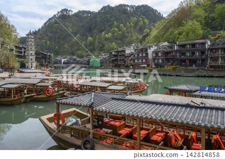 Wooden Chinese boats and Wanming medieval seven-tiered pagoda on Tuojiang river in Fenghuang, China Wooden Chinese boats and Wanming medieval seven-tiered pagoda on Tuojiang river in Fenghuang, China 142814858