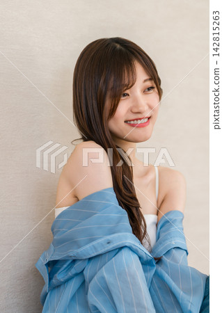 一位身穿藍色襯衫的女子麵帶微笑。清新休閒的時尚風格。 142815263