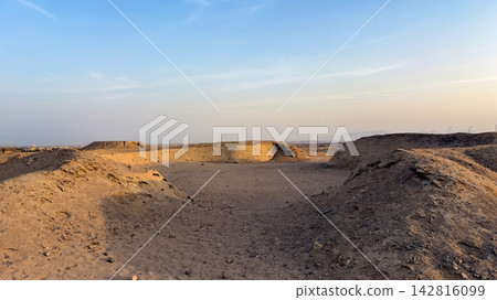 Arid desert landscape with sandy hills under a clear blue sky Arid desert landscape with sandy hills under a clear blue sky 142816099