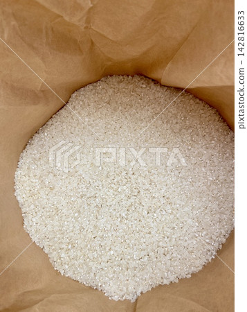 新鮮碾磨的新米、白米、牛皮紙米袋背景 | 秋季食品廣告、促銷材料、POP、包裝、光澤米粒 新鮮碾磨的新米、白米、牛皮紙米袋背景 | 秋季食品廣告、促銷材料、POP、包裝、光澤米粒 142816633