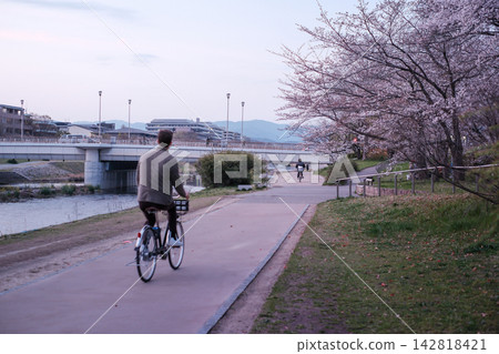 A bicycle riding along the Kamo River at dusk A bicycle riding along the Kamo River at dusk 142818421