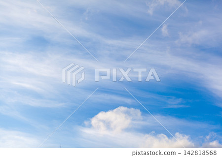 Clear blue sky featuring soft white clouds and wispy formations, providing a tranquil backdrop during daylight hours Clear blue sky featuring soft white clouds and wispy formations, providing a tranquil backdrop during daylight hours 142818568