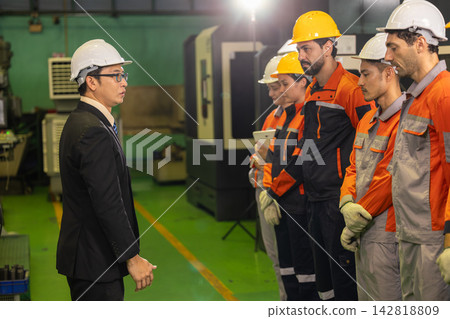 Angry chief engineer confronting factory workers. Poor performance and production failure during industrial manufacturing operation. 142818809