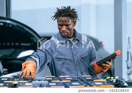 EV Battery Service Technician Inspecting Electric Car Lithium Ion Module Garage Repair EV Battery Service Technician Inspecting Electric Car Lithium Ion Module Garage Repair 142818854