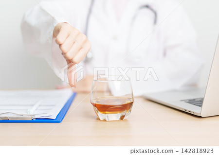 Doctor hand show thumb down to Whisky, quitting drink for healthy liver, prevent Alcoholic cirrhosis and cancer, World No Alcohol Day, medical advice for sobriety and Alcoholism and addiction concept Doctor hand show thumb down to Whisky, quitting drink for healthy liver, prevent Alcoholic cirrhosis and cancer, World No Alcohol Day, medical advice for sobriety and Alcoholism and addiction concept 142818923