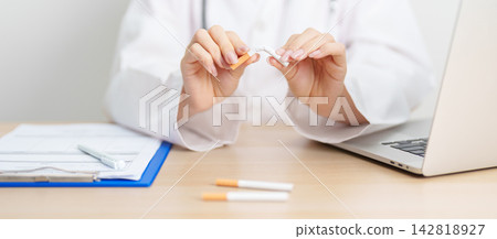 doctor hand making stop sign to refuse and breaking cigarette, quitting smoking for healthy lungs, prevent Lung Cancer and Emphysema, World No Tobacco Day concept 142818927