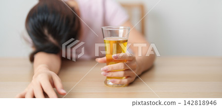 Stressed woman drinking beer alone with problem. Exhausted drunk woman looking stressed and sleepy. Alcohol addiction, Alcoholism, emotional distress and mental health concept 142818946