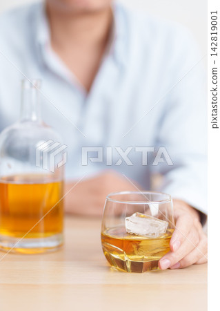 man with glass of whiskey on table, suffering from alcohol addiction and alcoholism concept. depicting emotional distress, depression, substance abuse problem, unhealthy lifestyle and mental health man with glass of whiskey on table, suffering from alcohol addiction and alcoholism concept. depicting emotional distress, depression, substance abuse problem, unhealthy lifestyle and mental health 142819001