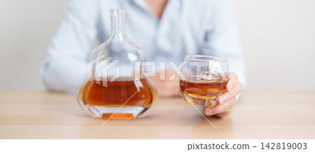 man with glass of cognac on table, suffering from alcohol addiction and alcoholism concept. depicting emotional distress, depression, substance abuse problem, unhealthy lifestyle and mental health man with glass of cognac on table, suffering from alcohol addiction and alcoholism concept. depicting emotional distress, depression, substance abuse problem, unhealthy lifestyle and mental health 142819003