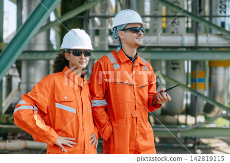 Refinery Engineers Woman Man Team Standing together in Industry Site Control Operate Plant job outdoors. Refinery Engineers Woman Man Team Standing together in Industry Site Control Operate Plant job outdoors. 142819115