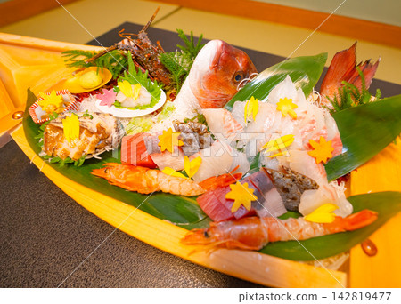 A boat-shaped platter lavishly filled with spiny lobster and sashimi. A boat-shaped platter lavishly filled with spiny lobster and sashimi. 142819477