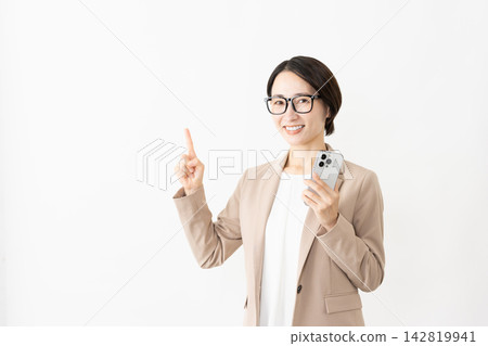 A woman in a suit and glasses using a smartphone. A woman in a suit and glasses using a smartphone. 142819941