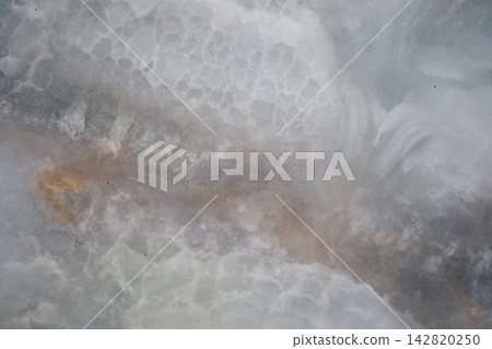 close-up view of a natural marble or onyx stone slab with cloudy, veined patterns close-up view of a natural marble or onyx stone slab with cloudy, veined patterns 142820250