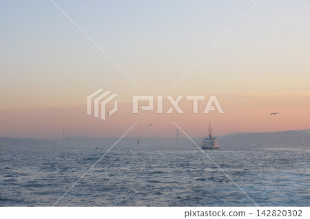 Water waves reflect light as a boat moves toward the horizon at sunset Water waves reflect light as a boat moves toward the horizon at sunset 142820302