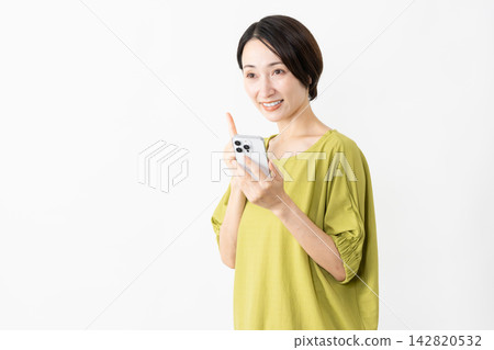 一位身穿T恤的女子正在使用智慧型手機——生活風格圖片 一位身穿T恤的女子正在使用智慧型手機——生活風格圖片 142820532