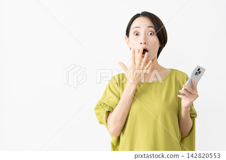 一位身穿T恤的女子正在使用智慧型手機——生活風格圖片 一位身穿T恤的女子正在使用智慧型手機——生活風格圖片 142820553