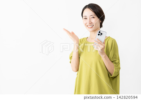 A woman in a T-shirt using a smartphone - Lifestyle image A woman in a T-shirt using a smartphone - Lifestyle image 142820594