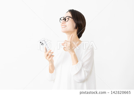 一位戴著眼鏡、身穿T恤的女士正在使用智慧型手機——生活方式圖片 一位戴著眼鏡、身穿T恤的女士正在使用智慧型手機——生活方式圖片 142820665