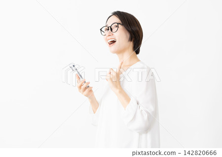 一位戴著眼鏡、身穿T恤的女士正在使用智慧型手機——生活方式圖片 142820666