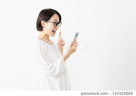 一位戴著眼鏡、身穿T恤的女士正在使用智慧型手機——生活方式圖片 一位戴著眼鏡、身穿T恤的女士正在使用智慧型手機——生活方式圖片 142820668