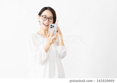 一位戴著眼鏡、身穿T恤的女士正在使用智慧型手機——生活方式圖片 142820669