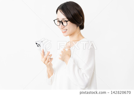 一位戴著眼鏡、身穿T恤的女士正在使用智慧型手機——生活方式圖片 一位戴著眼鏡、身穿T恤的女士正在使用智慧型手機——生活方式圖片 142820670