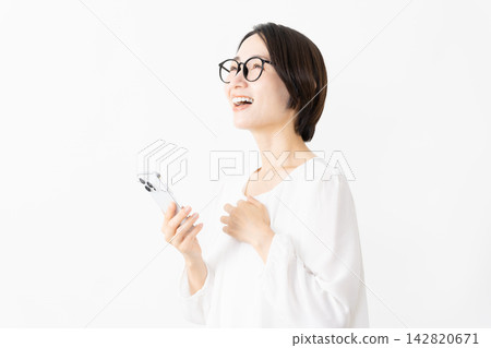 一位戴著眼鏡、身穿T恤的女士正在使用智慧型手機——生活方式圖片 一位戴著眼鏡、身穿T恤的女士正在使用智慧型手機——生活方式圖片 142820671