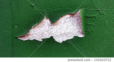 Peeling green paint reveals a white surface. Peeling green paint reveals a white surface. 142820722