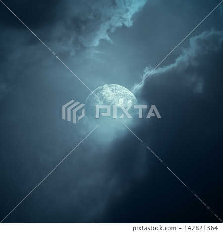 Full moon glowing through dramatic dark storm clouds in a moody blue night sky. Smoke background Full moon glowing through dramatic dark storm clouds in a moody blue night sky. Smoke background 142821364