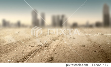 Apocalyptic landscape with a barren dirt ground featuring tire tracks and a heavily blurred city skyline shrouded in smog in background. Concept of nature, disaster, climate, environment, or weather Apocalyptic landscape with a barren dirt ground featuring tire tracks and a heavily blurred city skyline shrouded in smog in background. Concept of nature, disaster, climate, environment, or weather 142821517