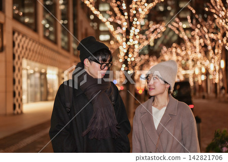 A young couple gazing into each other's eyes under the illuminations. A young couple gazing into each other's eyes under the illuminations. 142821706