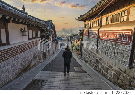 Seoul South Korea sunrise of Korean traditional house at Bukchon Hanok Village with woman tourist 142822382