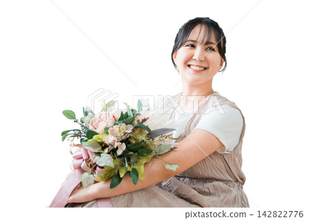 A stylish woman holding a swag of dried flowers A stylish woman holding a swag of dried flowers 142822776