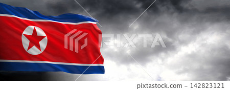 North Korea Flag Waving Against Dark Cloudy Sky North Korea Flag Waving Against Dark Cloudy Sky 142823121