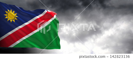Namibia Flag Waving Against Dark Cloudy Sky Namibia Flag Waving Against Dark Cloudy Sky 142823136