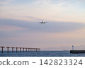 一架客機在黃昏時分飛越海，開始下降準備降落。 142823324