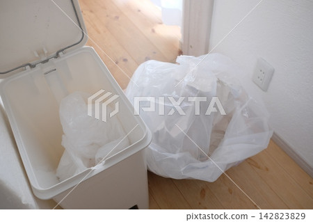 Replacing the trash bag in the bathroom trash can. Replacing the trash bag in the bathroom trash can. 142823829