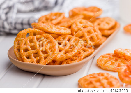 Seasoned Waffle Potato Chips Piled On Plate. Closeup Of Crispy Savory Snack Seasoned Waffle Potato Chips Piled On Plate. Closeup Of Crispy Savory Snack 142823933