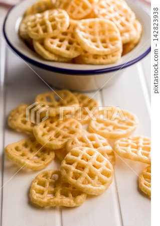 Stack of Waffle Potato Chips and Crisps on White Tabletop Snack Platter 142823938