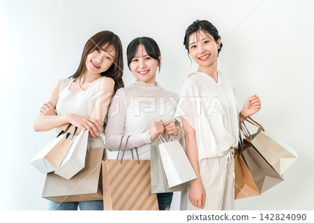 Three young women, smiling and enjoying shopping with shopping bags in hand. Three young women, smiling and enjoying shopping with shopping bags in hand. 142824090