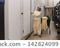 Senior woman shopping for doors and hardware, renovating her home 142824099