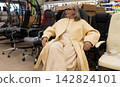 Woman sitting on an ergonomic chair, shopping for new furniture at a modern store 142824101