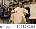 Mature woman sitting comfortably in an ergonomic office chair, shopping for furniture 142824104