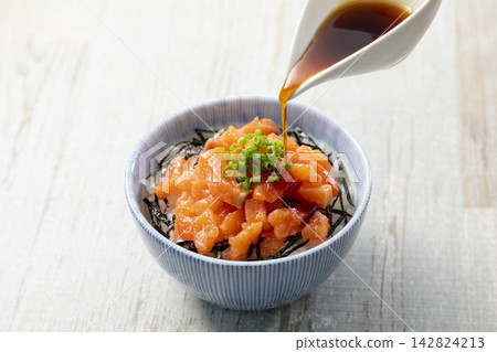 The scene where soy sauce is poured over salmon rice bowl The scene where soy sauce is poured over salmon rice bowl 142824213