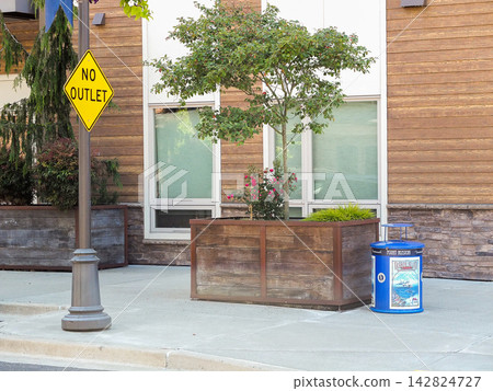 Bright yellow No Outlet road sign next to a rustic wooden planter box on a street sidewalk.- June 13, 2026 Ruston WA, USA Bright yellow No Outlet road sign next to a rustic wooden planter box on a street sidewalk.- June 13, 2026 Ruston WA, USA 142824727